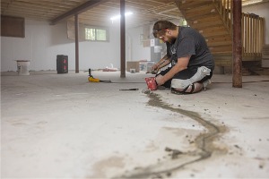 A man helping repair a basement's foundation during basement waterproofing in Peoria IL