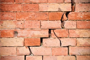 A damaged brick wall is seen. K-Mag Basement Solutions performs Foundation Crack Repair in East Peoria IL. 