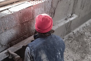 A foundation expert is seen repairing a foundation. K-Mag Basement Solutions is one of the best Basement Contractors in East Peoria IL.