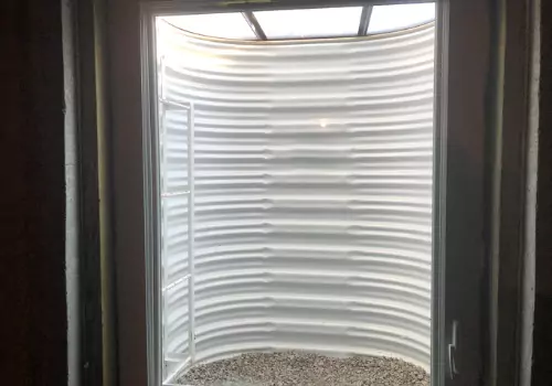 A window well is seen. Basement Systems Waterproofing & Foundation installs window wells and Egress Windows in Peoria IL.