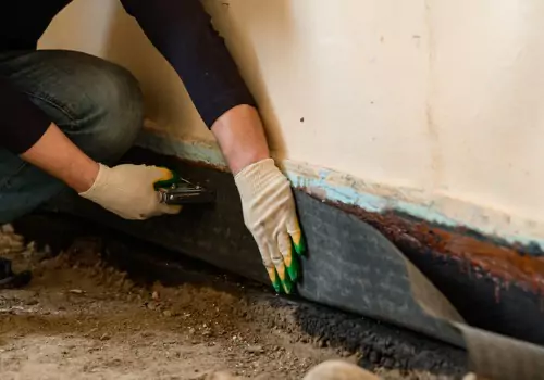 A tech performs foundation waterproofing. K-Mag performs Foundation Waterproofing in East Peoria IL.