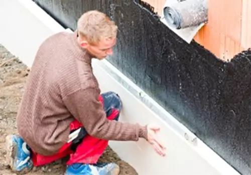 A tech waterproofings a foundation. Basement Systems Waterproofing & Foundation handles Foundation Waterproofing in East Peoria IL.